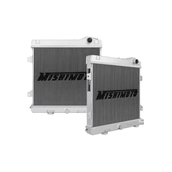 Mishimoto aluminum radiator for BMW E30 M3, 1987-1991, with dual core design and mounting brackets, in a car engine bay.